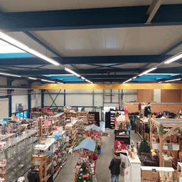 Overzicht van de winkelvloer met diverse stellingen en uitgestalde spullen in een kringloopwinkel