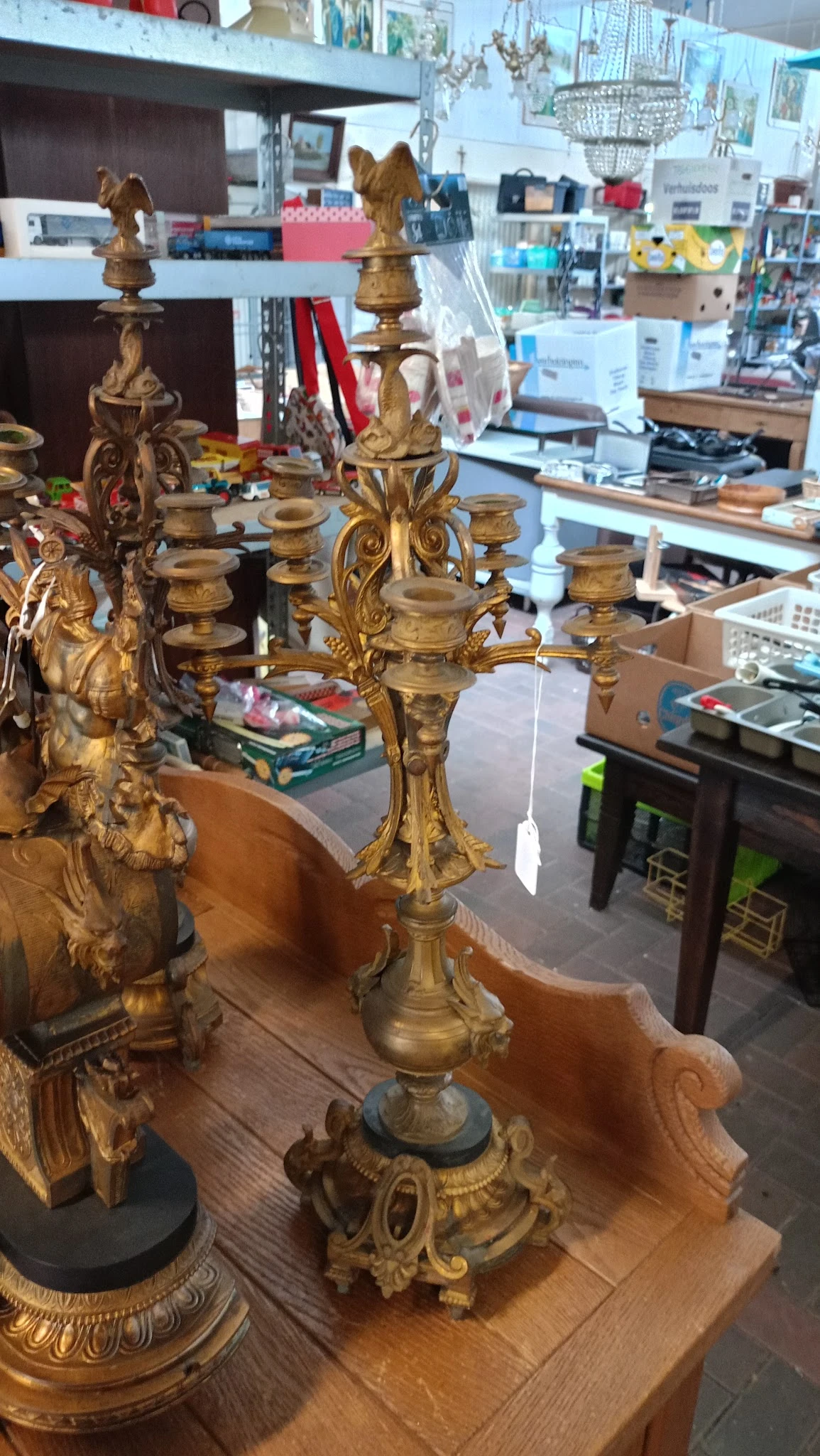 Gouden kandelaar met vier armen en ornamentale versiering op houten tafel