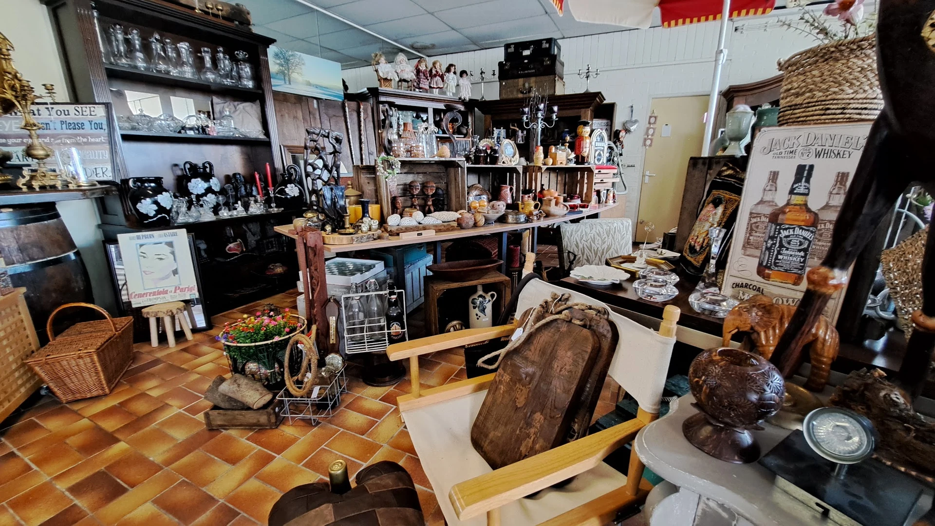 Winkelvloer met vintage meubels, decoratiestukken en uitgestalde waar in een kringloopwinkel