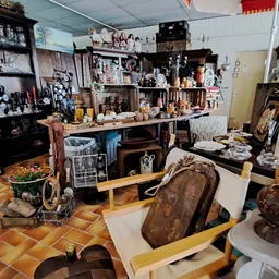 Winkelvloer met vintage meubels, decoratiestukken en uitgestalde waar in een kringloopwinkel