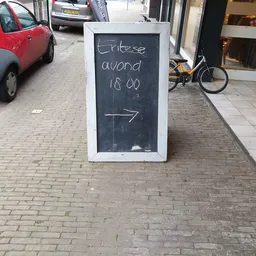 Krijtbord met handgeschreven tekst 'Erbse avond 18.00' en een pijl