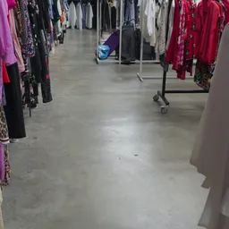 Winkelruimte met kledingrekken aan beide zijden en kleding op hangrekken