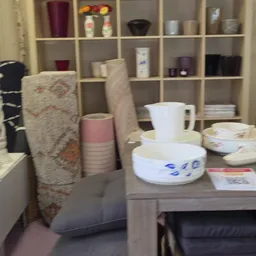 Tafelscène met servies, bekers en rolletjes behang op een grijs werkblad