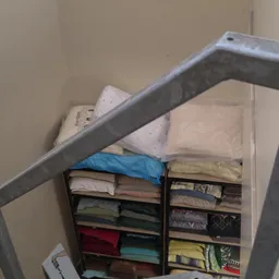 Stellingen met gestapelde linnen en beddengoed in verschillende kleuren