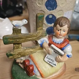 Vintage porseleinen beeldje van een meisje met kruissteekwerk en houten kruissteekframe