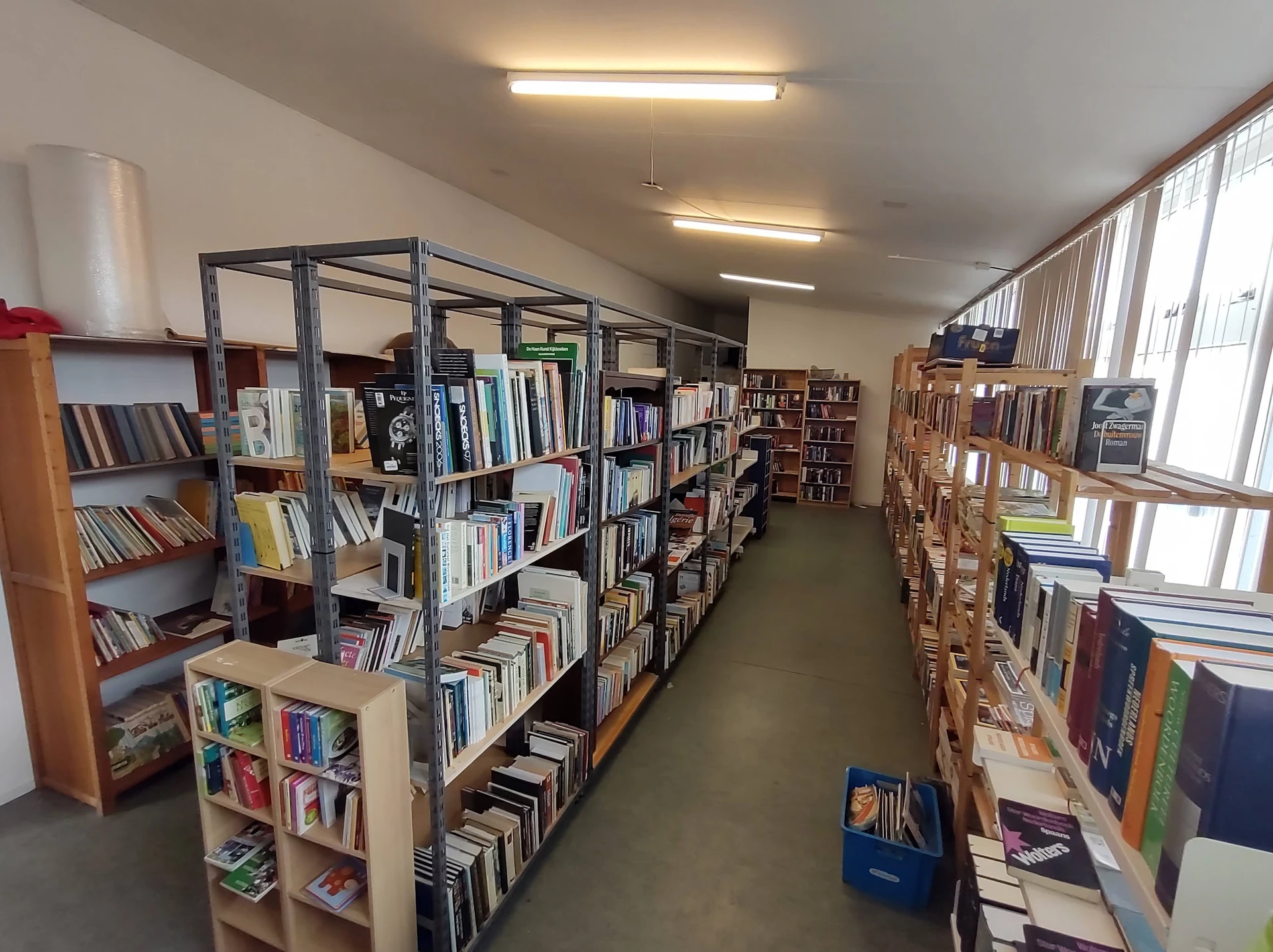 Boekenrekken en stellingen met tweedehands boeken en media in de winkelruimte