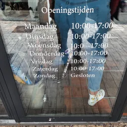 Openingstijden op een deur: maandag tot zaterdag 10:00-17:00, zondag gesloten