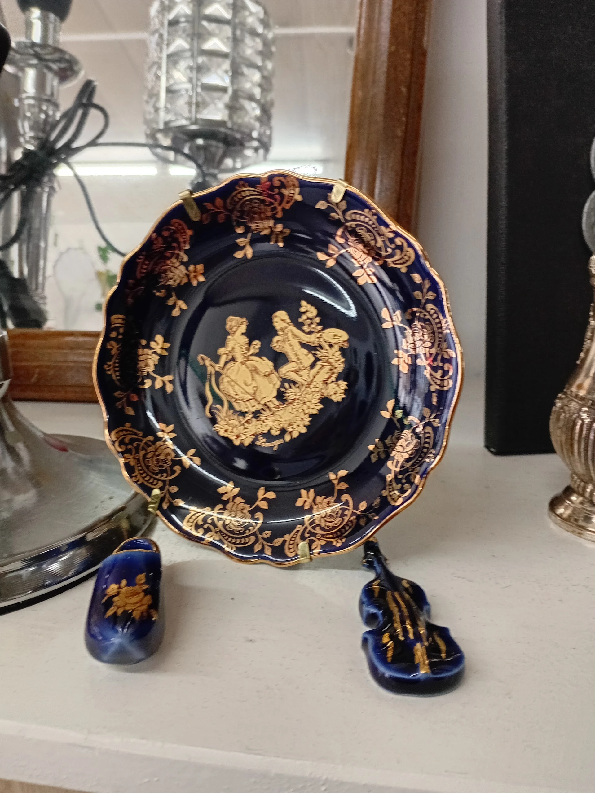Decoratief bord met donkerblauwe glazuur en goudkleurige versiering met figuren
