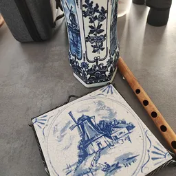 Blauw-wit Delfts aardewerk: een decoratieve tegel met molenmotief en een ornamentale vaas