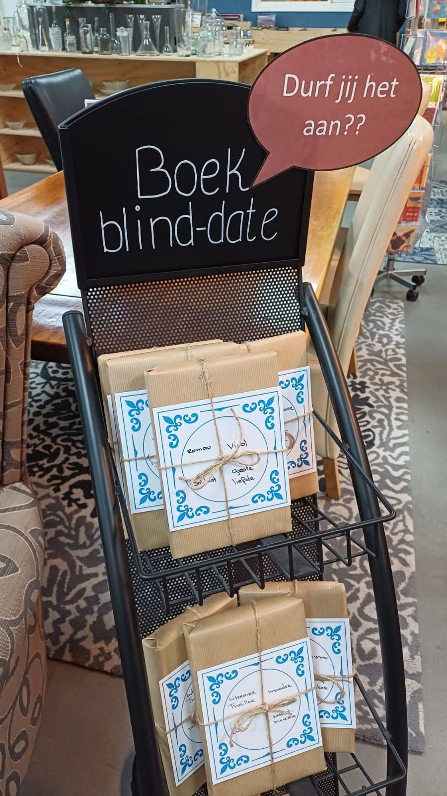Ingepakt cadeautje met blauwe decoratieve verpakking en handgeschreven labels in een winkelrekje