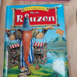 Kinderboek 'Bij de Reuzen' met illustratie van een reus met rode baard en blauwe hoed