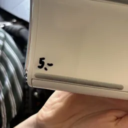 Close-up van een beige kleurig apparaat met het getal '5' erop geschreven