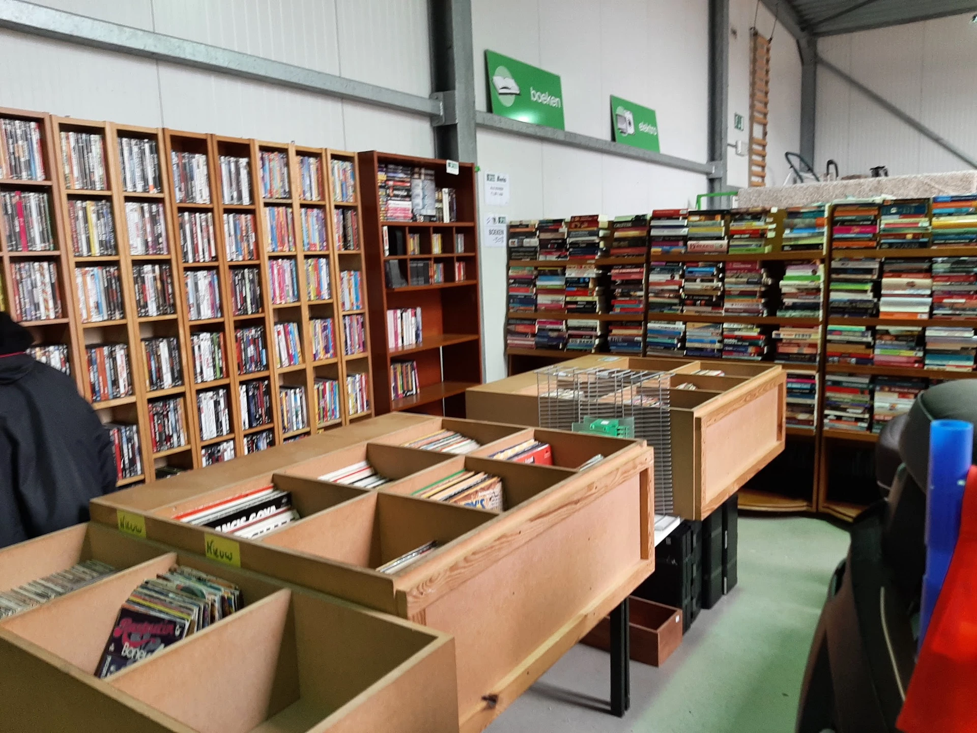 Winkelinterieur met grote kartonnen dozen op de vloer en volle boekrekken langs de muren