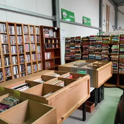 Winkelinterieur met grote kartonnen dozen op de vloer en volle boekrekken langs de muren