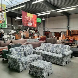 Winkelvloer met uitgestalde meubels waaronder banken en fauteuils met bloemenprint