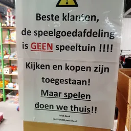 Wit papier met zwarte en rode tekst over speelgoedafdeling en spelregels
