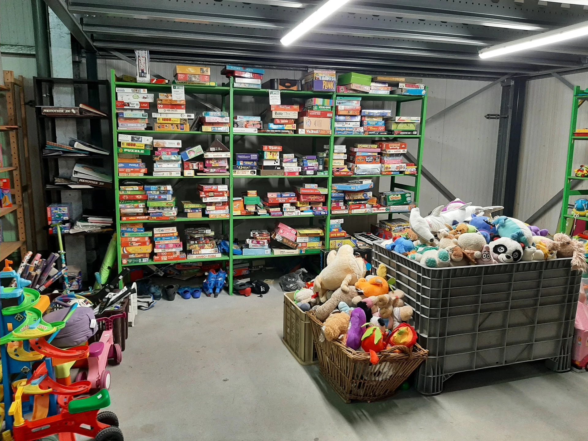 Winkelvloer met groene stellingen vol speelgoed en dozen, kinderspeelgoed in foreground