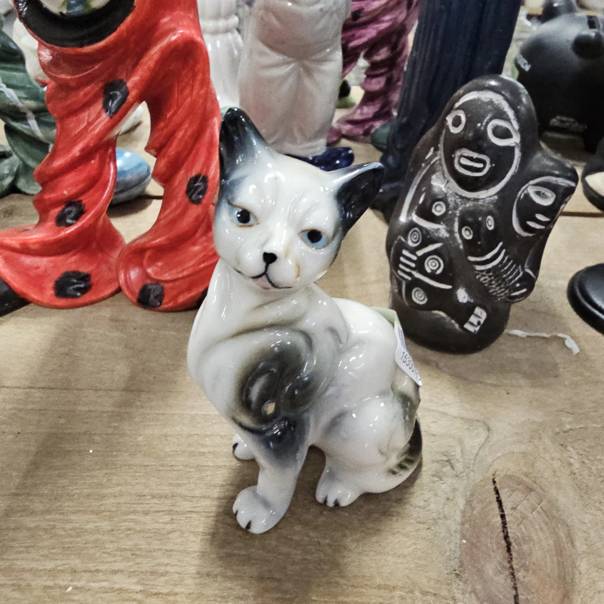 Witte keramische kat met zwarte details, zittend, onder andere decoratieve voorwerpen