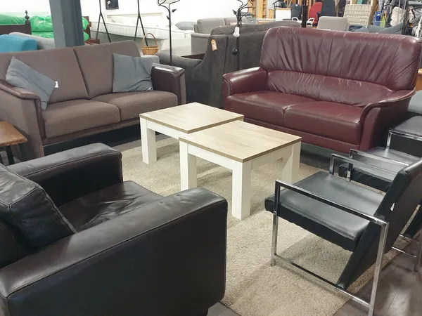 Woonkamer inrichting met meerdere banken en salontafels in een kringloopwinkel