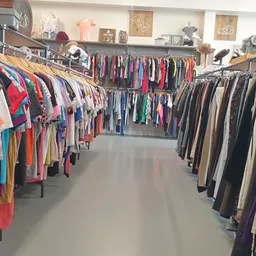 Rekken met tweedehands kleding in verschillende kleuren en stijlen in de winkel