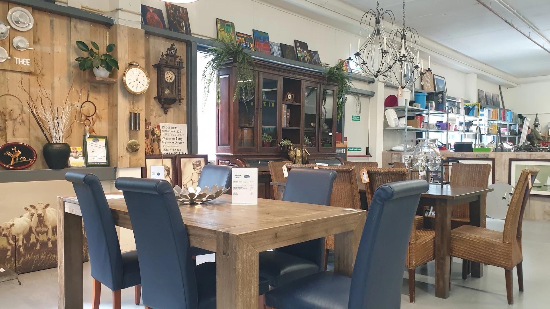 Winkelbinnenruimte met houten eettafel, blauwe stoelen en vintage meubels tegen de wand