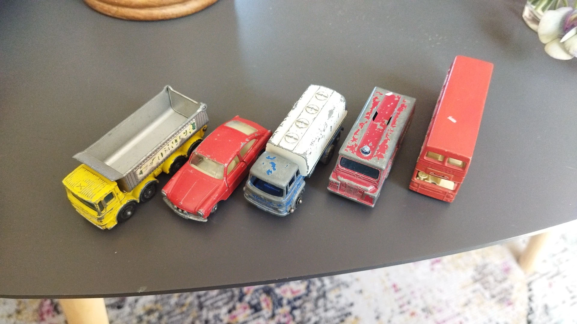 Verzameling speelgoedauto's uitgestald op een grijze tafel