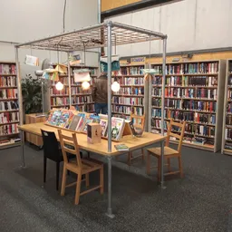 Boekenrek met tafel en stoelen in een bibliotheekruimte met boekenkasten op de achtergrond