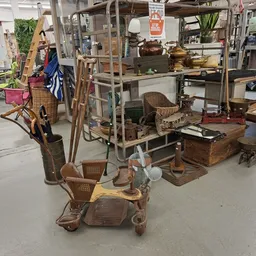 Diverse vintage meubels en huishoudartikelen uitgestald in de winkel, waaronder stoelen, tafels, lampen en decoratieve voorwe