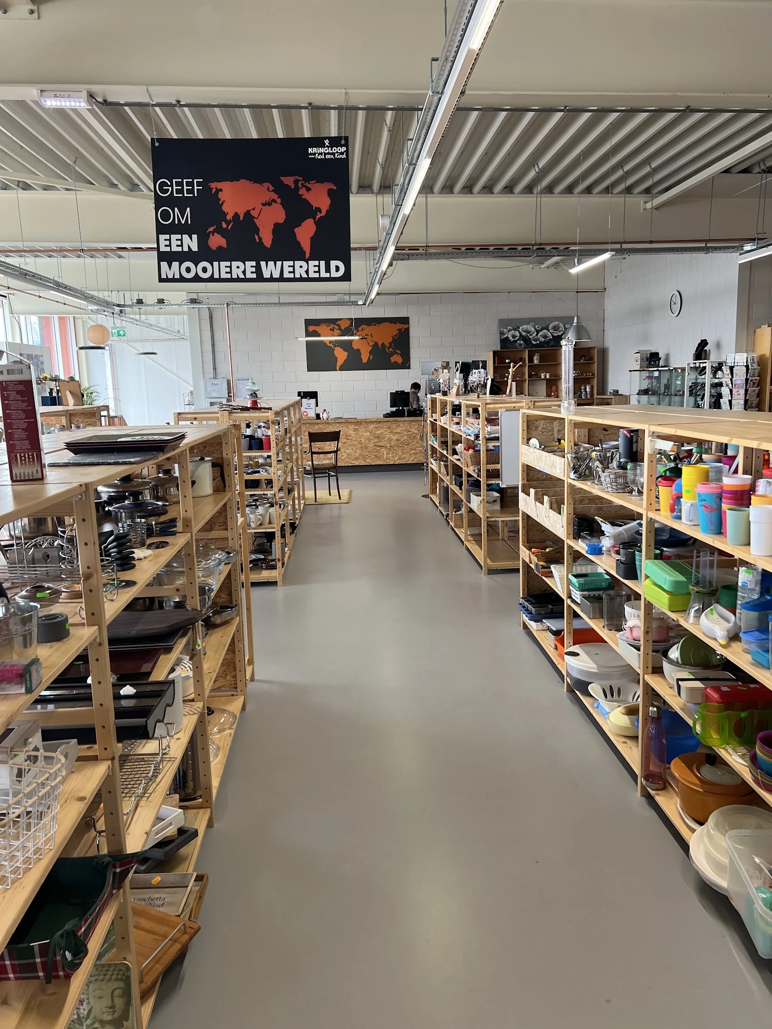 Winkelvloer met houten stellingen vol met huishoudspullen, servies en voorraden