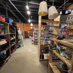 Overzicht van de winkelvloer met houten stellingen, diverse artikelen en producten, oranje muur op achtergrond
