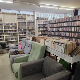 Winkelvloer met boekenkast, cd-rekken, fauteuils en zithoeken in tweedehands winkel