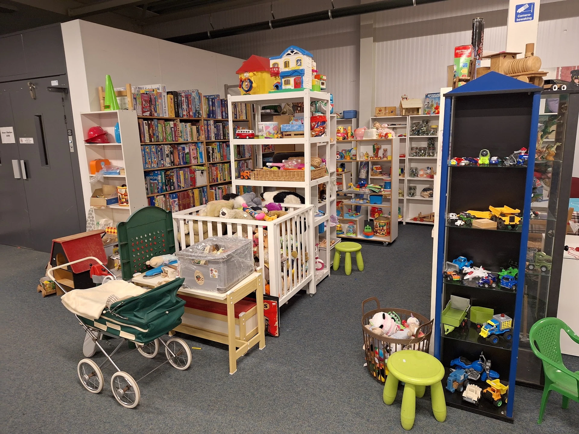 Winkelvloer met speelgoedafdelingen, boeken, poppenwagen en kinderspeelgoed uitgestald