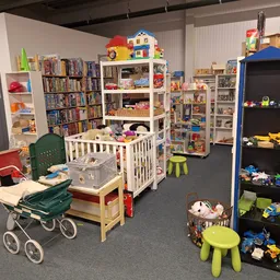 Winkelvloer met speelgoedafdelingen, boeken, poppenwagen en kinderspeelgoed uitgestald