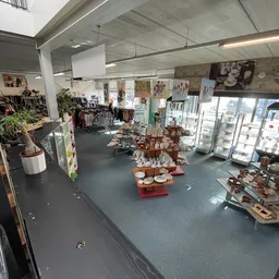 Overzicht van winkelvloer met diverse spullen, stellingen en koopwaar uitgestald in kringloopwinkel