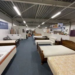 Uitgestalde matrassen en bedden in verschillende maten en stijlen in de winkel