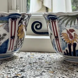 Twee decoratieve porseleinen kannen met blauw-wit patroon en bloemmotieven op een granito werkblad.