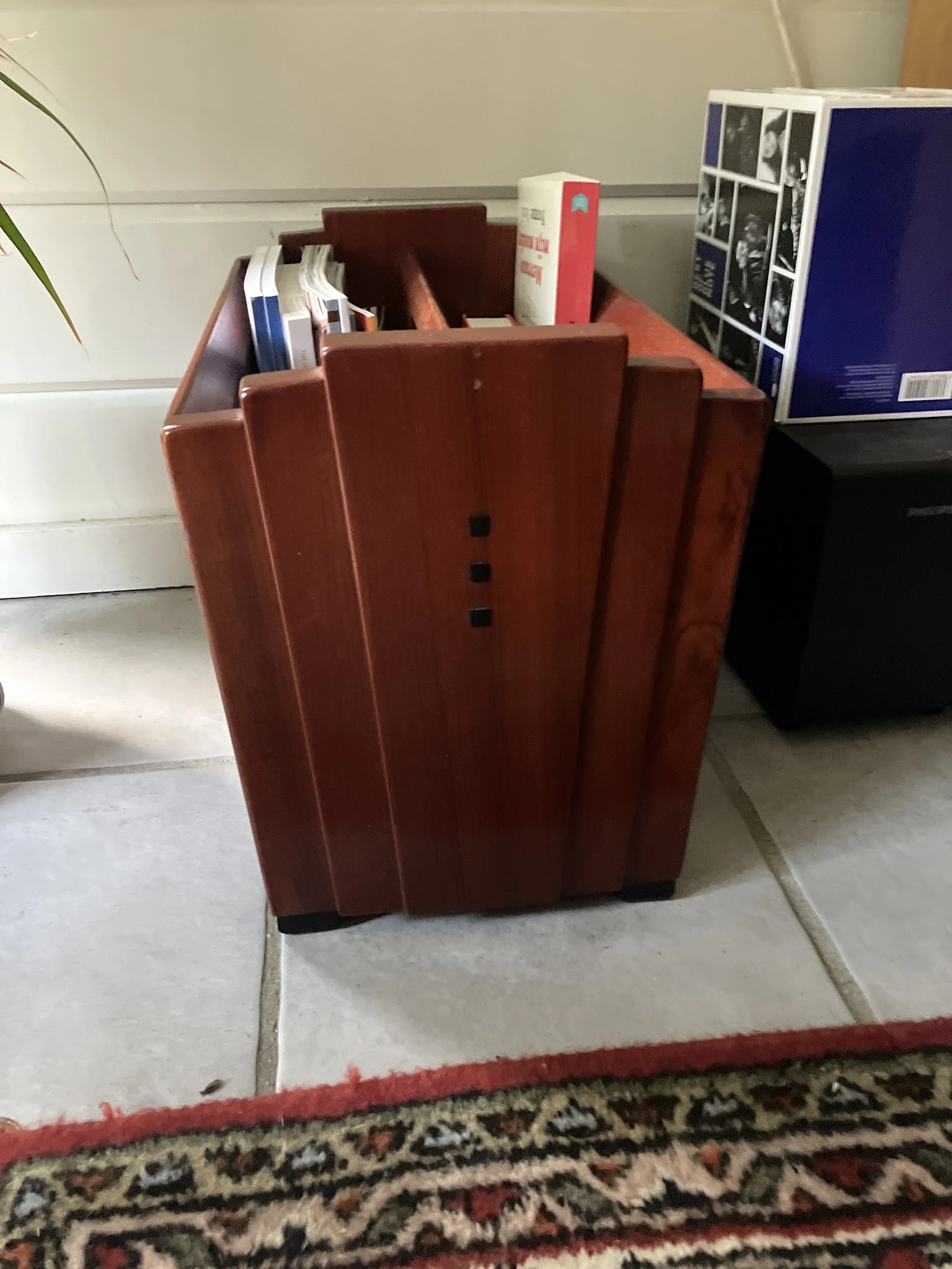 Roodbruin/terracottakleurig meubelstuk, mogelijk een kast of dressoir, met verticale lijnen en kleine zwarte knoppen