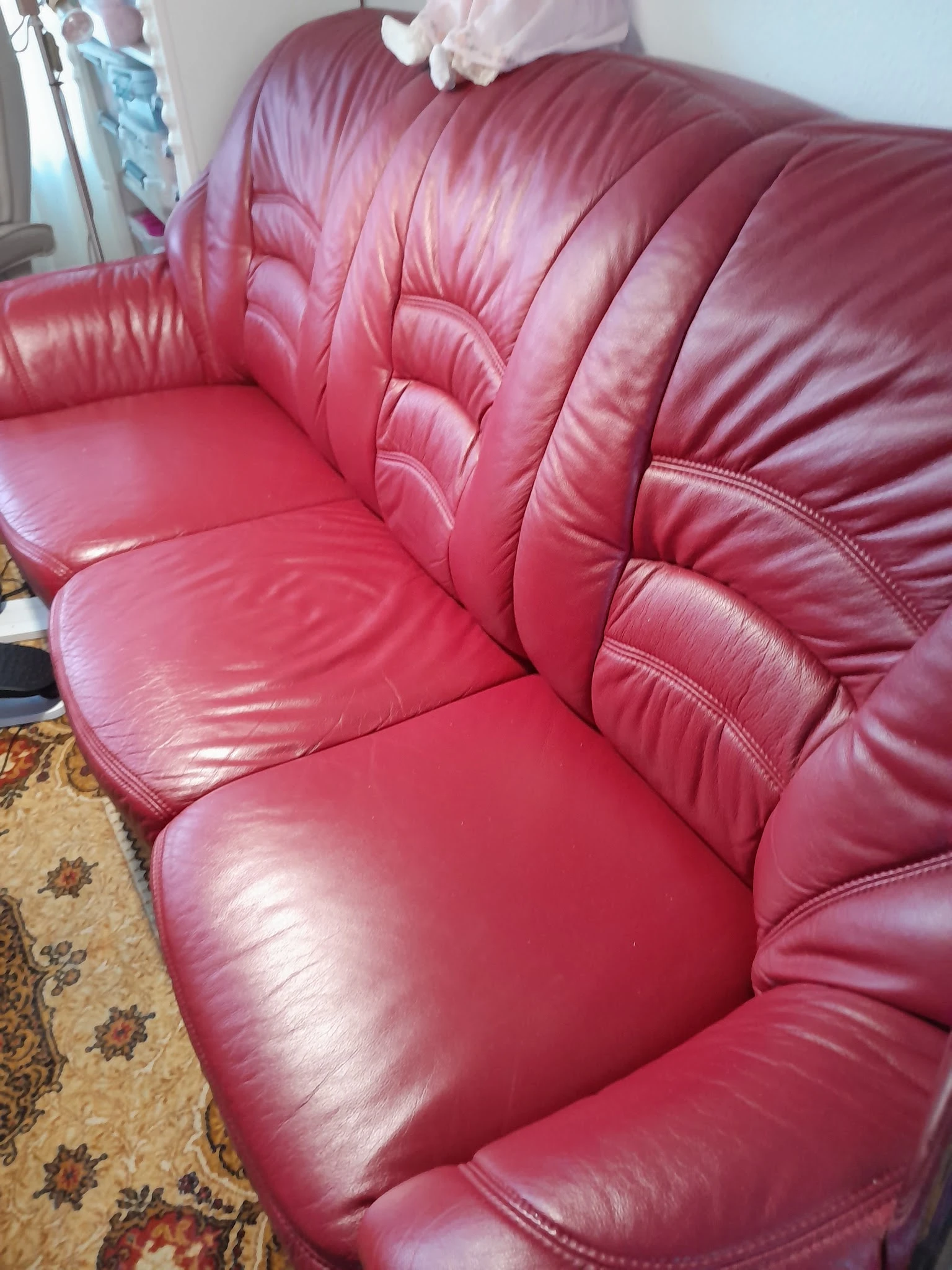 Close-up van een roze/rood lederen fauteuil met geplooide rugleuning