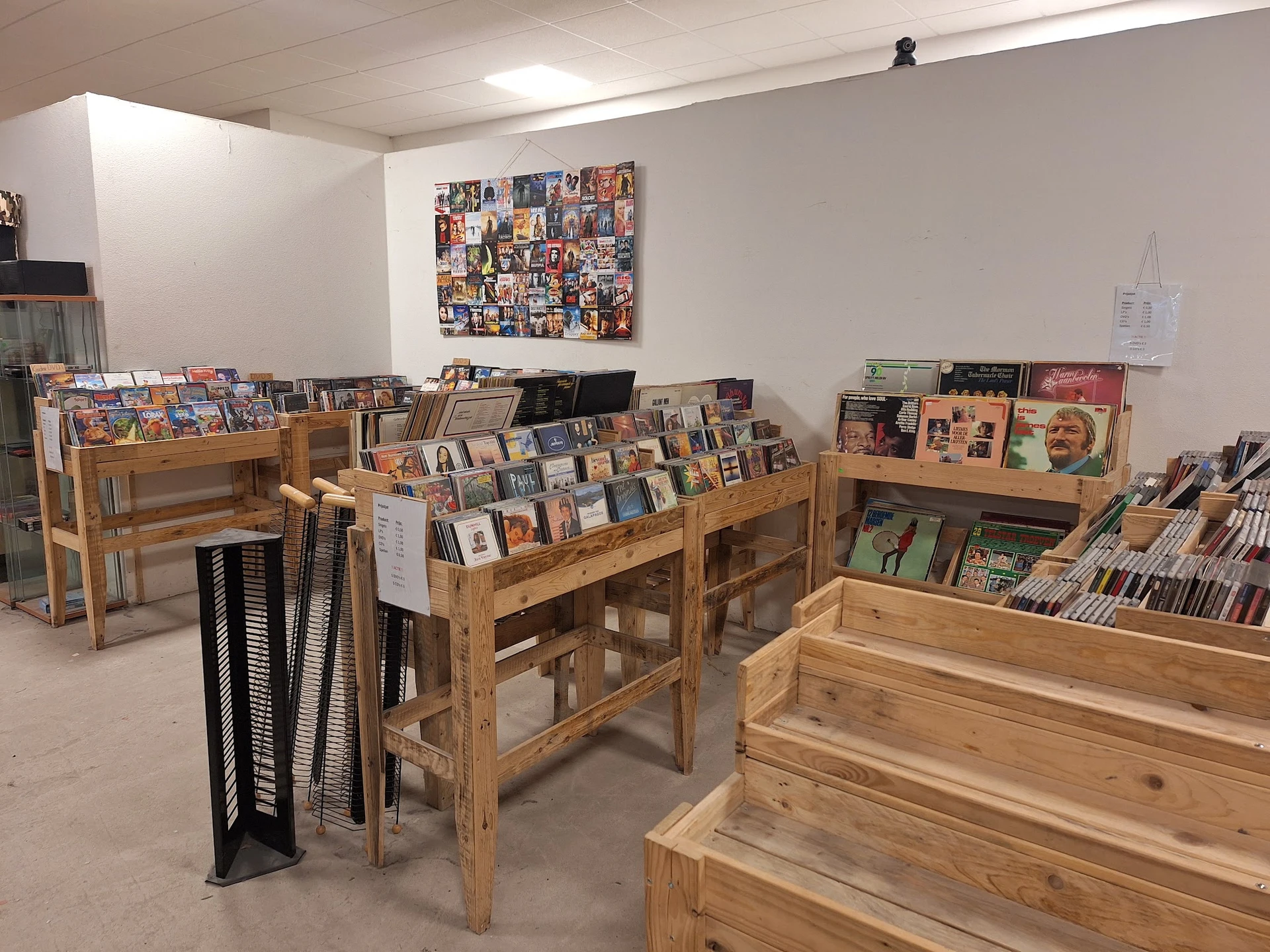 Winkelvloer met houten rekken vol cd's, dvd's en boeken, wanddecoratie met filmposters