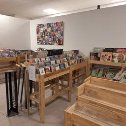 Winkelvloer met houten rekken vol cd's, dvd's en boeken, wanddecoratie met filmposters