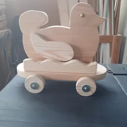 Houten speelgoed in de vorm van een eend op wielen, gemaakt van naturel hout.