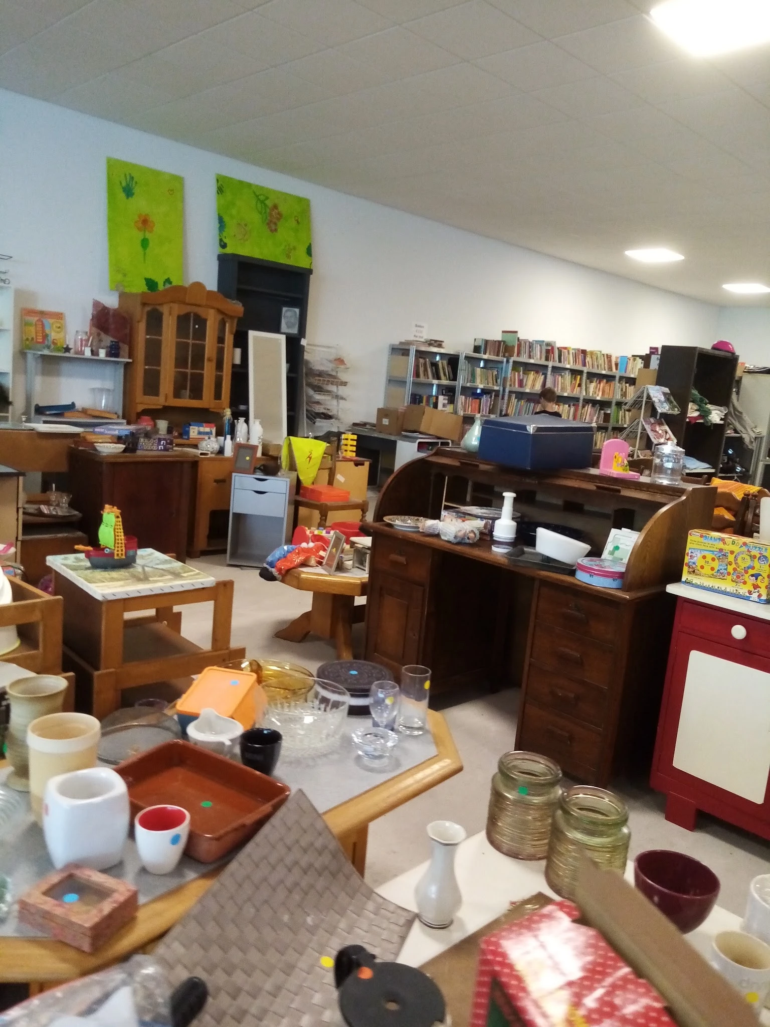 Winkelvloer met houten meubels, boekenkasten, serviesgoed en diverse tweedehandsartikelen