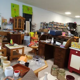 Winkelvloer met houten meubels, boekenkasten, serviesgoed en diverse tweedehandsartikelen