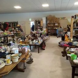 Overzicht van de winkelvloer met tafels, stellingen en uiteenlopende tweedehands spullen
