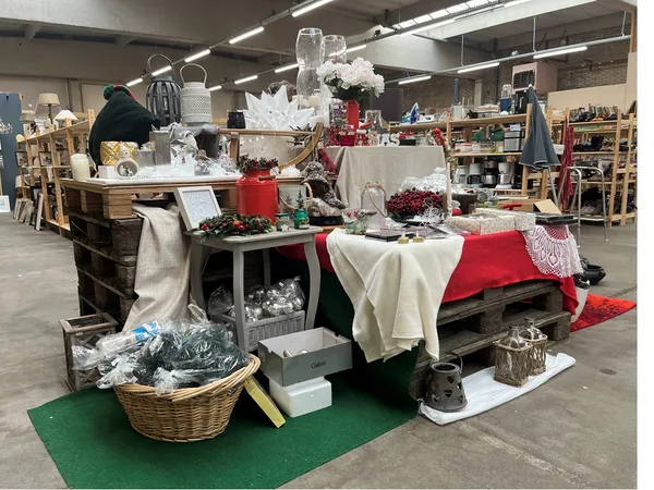 Winkelvloer met decoratieve display van kerstdecoraties, rode en witte stoffen, bloemen en seizoensartikelen op tafels