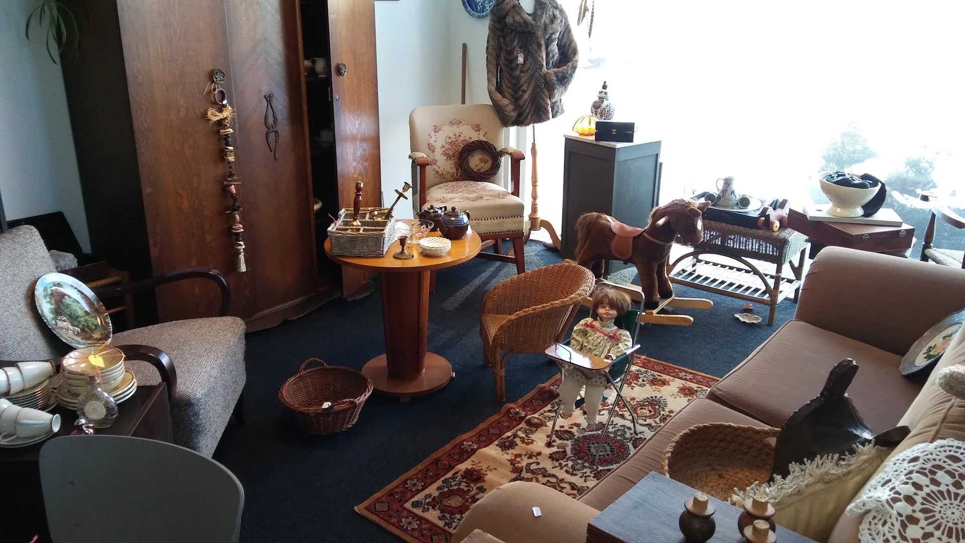 Interieur van kringloopwinkel met meubels, stoelen, tafels en huishoudelijke artikelen op blauwe vloer