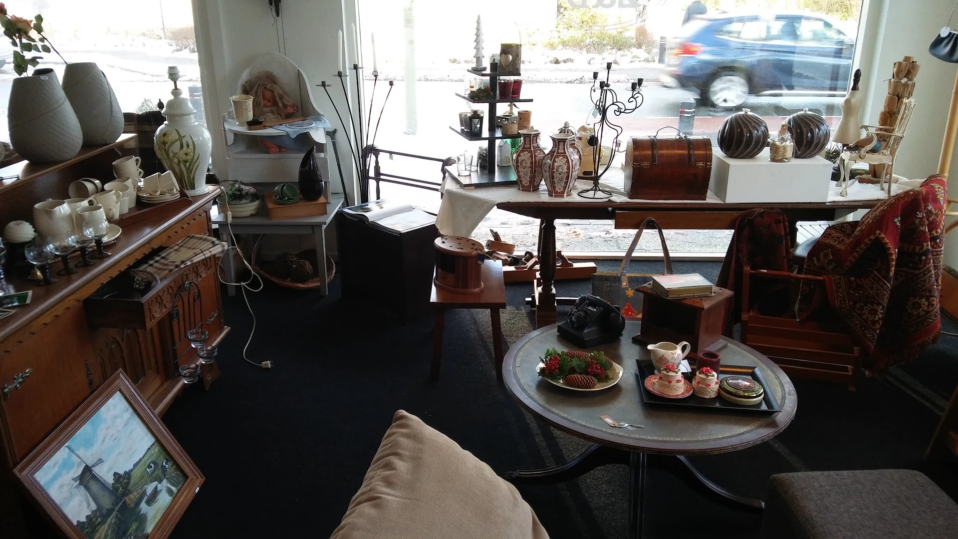 Interieur van kringloopwinkel met vintage meubels, decoratie en een uitgestalde tafel met eten