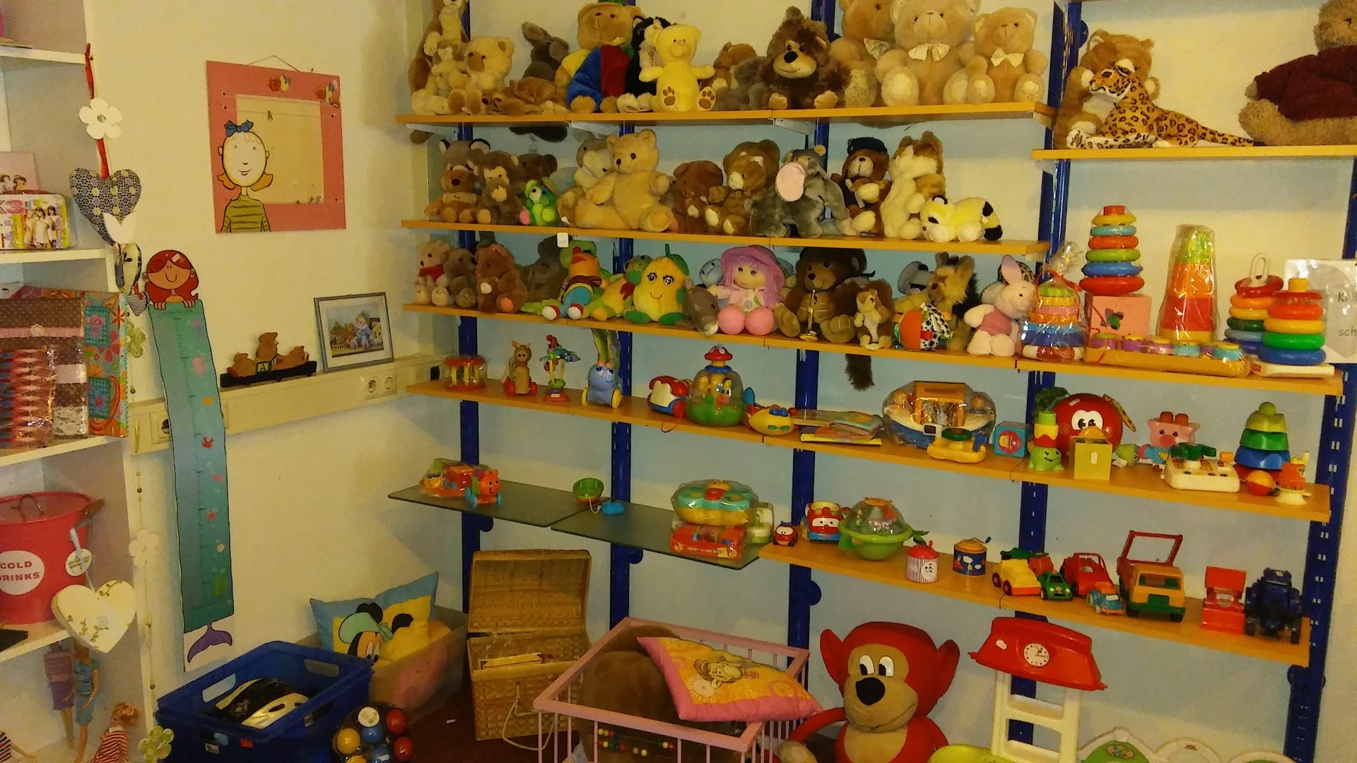 Houten stellingen vol met vintage speelgoed, knuffels en pluchen dieren in verschillende formaten en kleuren