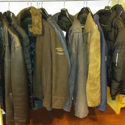 Rekken met tweedehands jassen en winterjassen in verschillende kleuren en maten