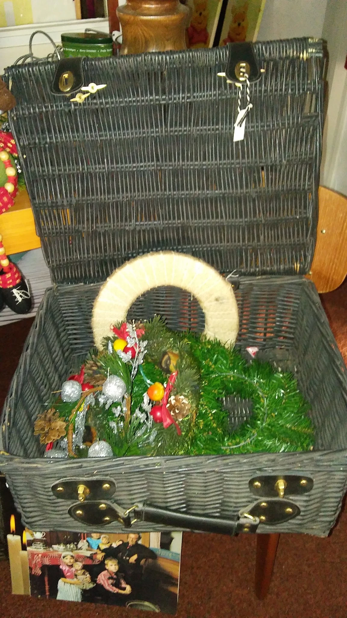 Witte krans met kunstbloemen in een grijze rieten mand